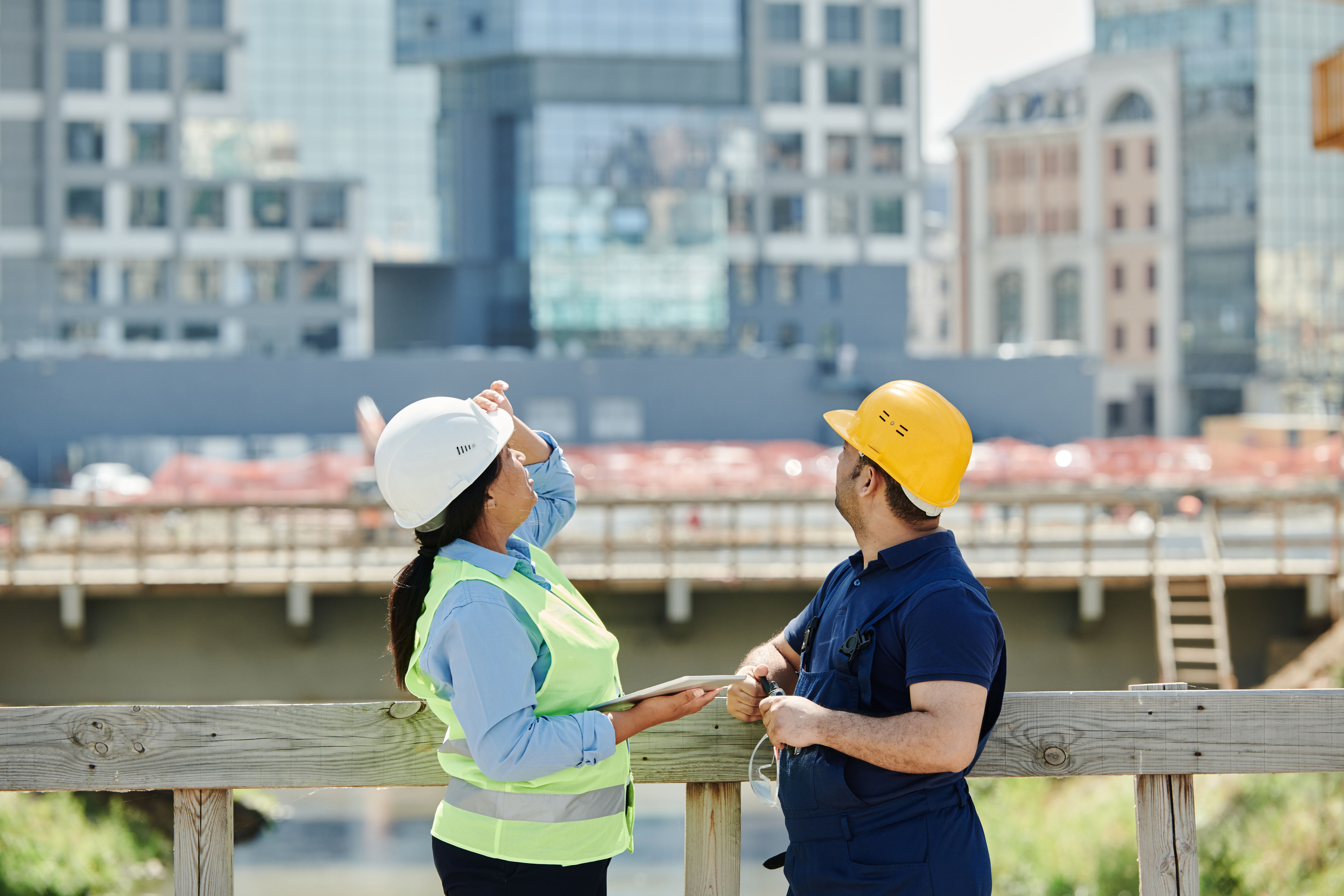 Constructori discutând lângă o clădire în construcție